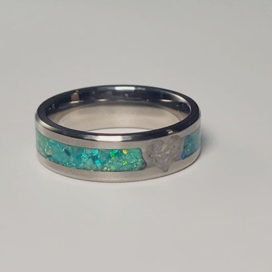 This titanium cremation ring is seen here with green opals that shimmer around the heart of ashes in the center of the 6mm ring.